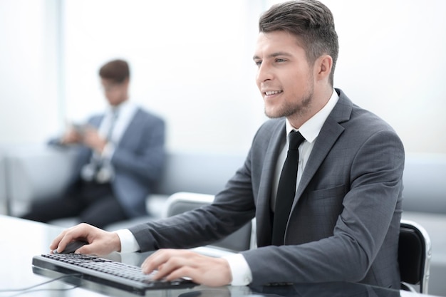 Image de deux jeunes collègues travaillant au bureau à l'aide d'ordinateurs et de téléphone