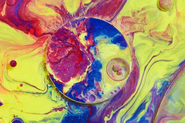 Image du cercle avec un cercle plus petit et des orbes sur une surface liquide arc-en-ciel multicolore