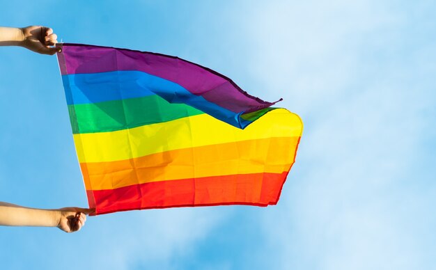 image du drapeau lgbt volant sous le ciel bleu