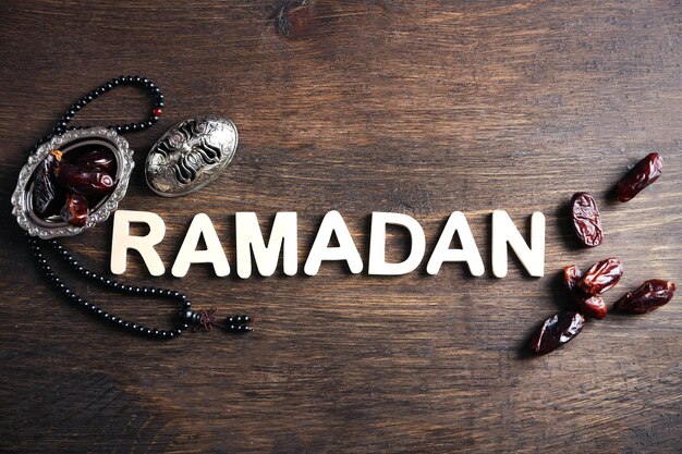 Image du mot RAMADAN avec chapelet et fruits de dattes sur fond bois gros plan