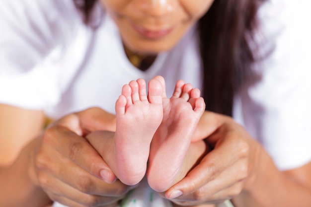 Image du pied de bébé nouveau-né dans les mains de la mère