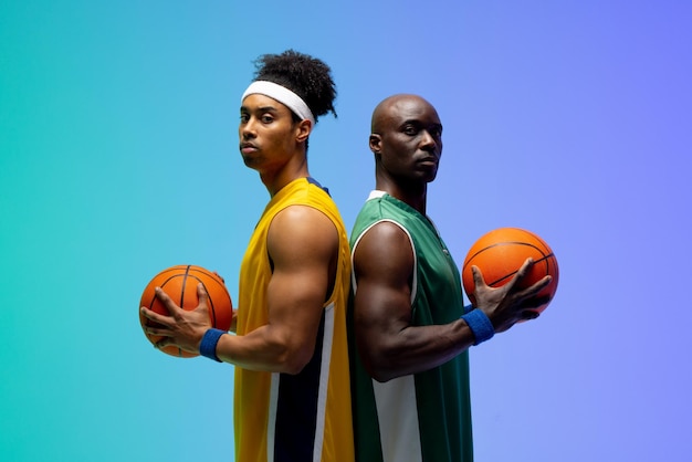 Image du portrait de deux joueurs de basket-ball divers avec des ballons de basket-ball sur fond violet à vert