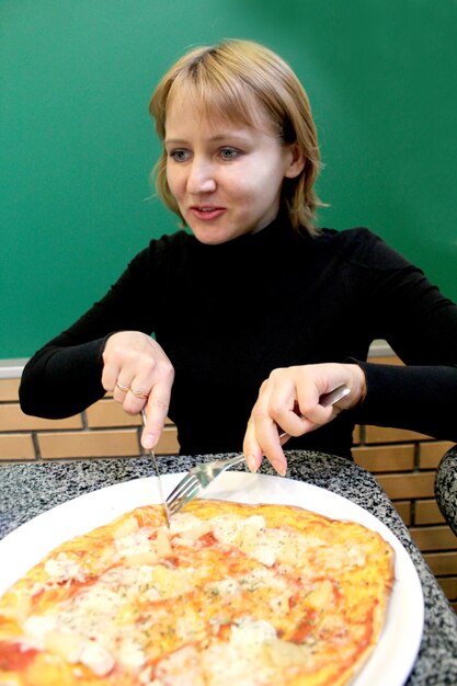 Image du portrait d'une jeune femme sympathique dans une pizzeria