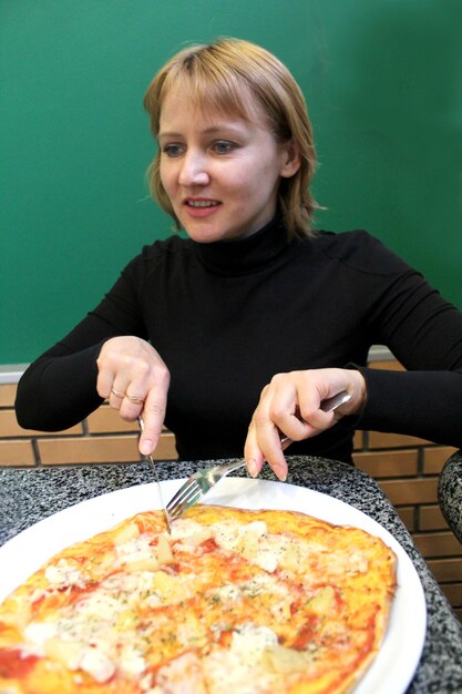 Image du portrait d'une jeune femme sympathique dans une pizzeria