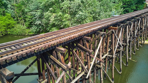 Image du vieux pont en bois de chemin de fer au-dessus de la rivière du côté aérien