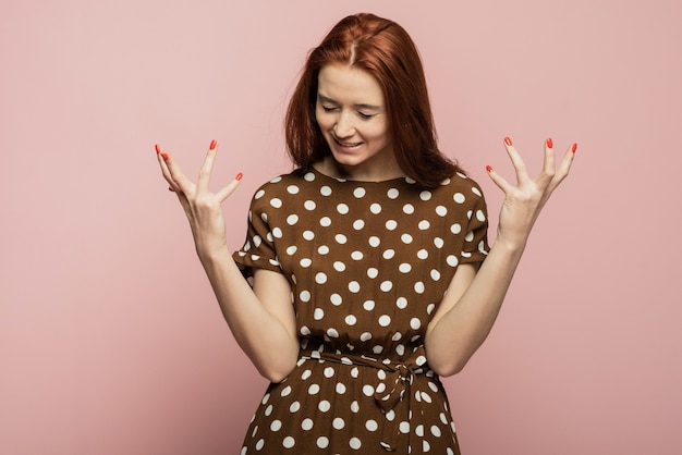 Image dynamique du modèle féminin caucasien sur fond de studio rose. Succès gagnant femme heureuse célébrant être un gagnant. Victoire, concept de plaisir. Concept d'émotions faciales humaines. Couleurs tendance