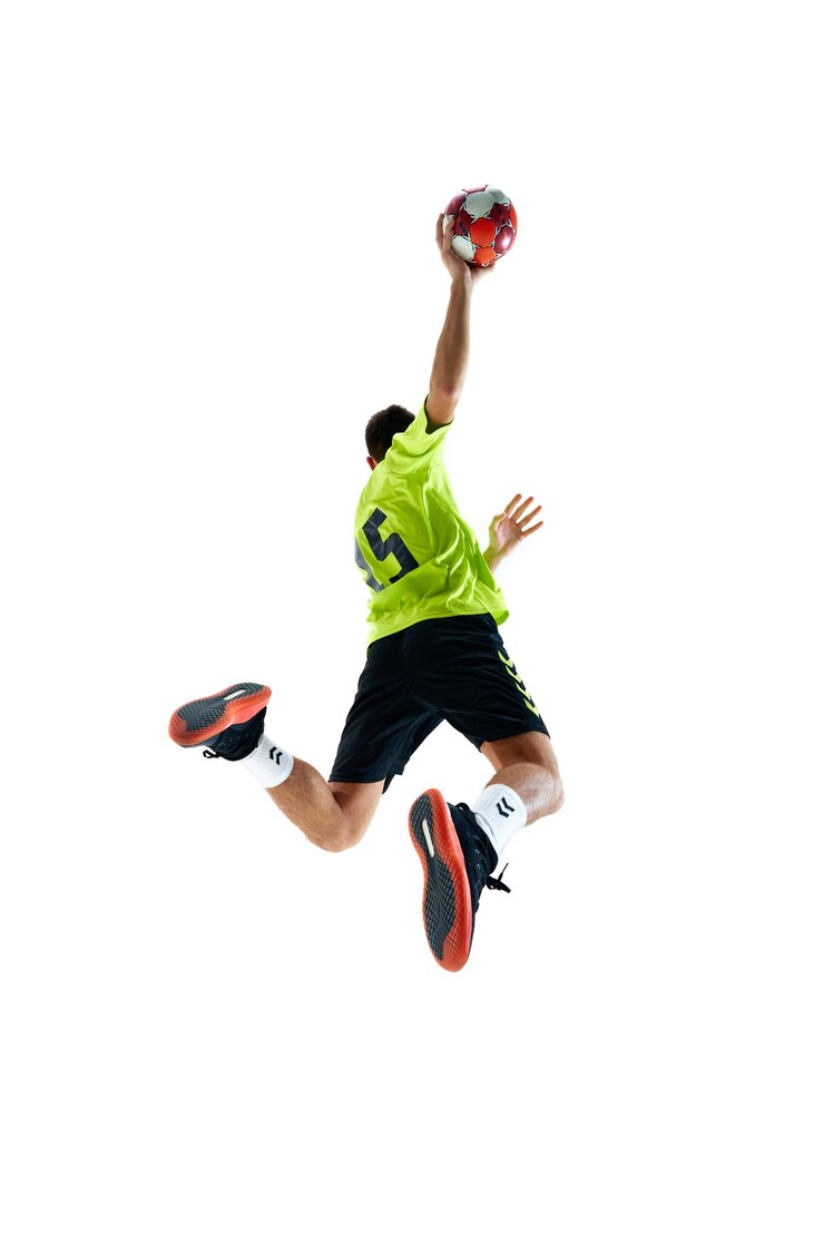 Photo image dynamique de retour d'un jeune homme en uniforme de handball jouant en mouvement en sautant avec la balle