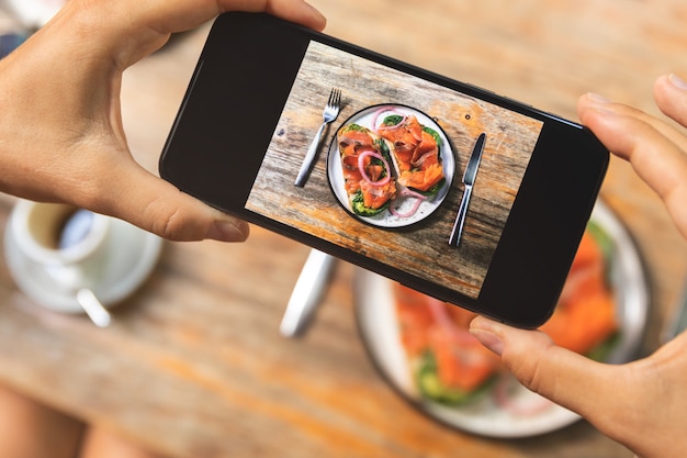 Image sur l'écran du smartphone de délicieux toasts avec un saumon fumé