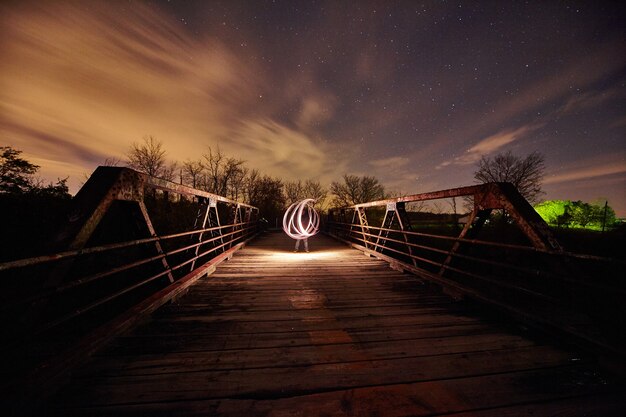 Image de l'expérience de la lumière sur un pont métallique au crépuscule