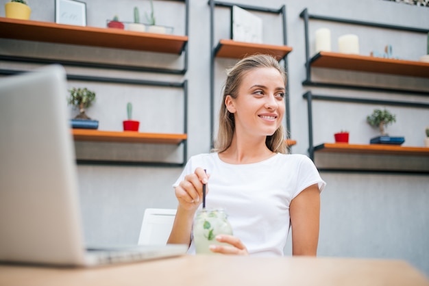 Image faible angle de fille souriante ayant rafraîchissement à l&#39;intérieur.