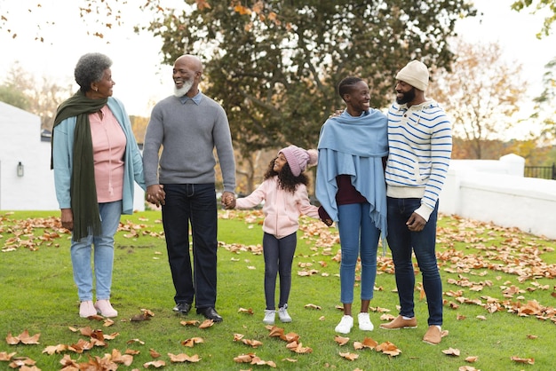 Photo image d'une famille afro-américaine heureuse de plusieurs générations s'amusant à l'extérieur en automne. famille élargie, passer du temps de qualité ensemble.