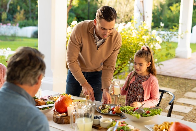 Image d'une famille caucasienne multigénérationnelle en train de dîner en plein air. Concept de famille et de passer du temps de qualité ensemble.