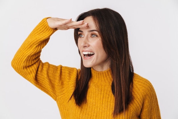 Image d'une femme adulte brune excitée portant un pull regardant de côté avec la main sur son front isolé sur blanc