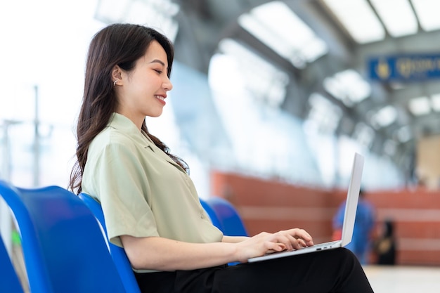 Image d'une femme d'affaires asiatique assise et travaillant à la gare