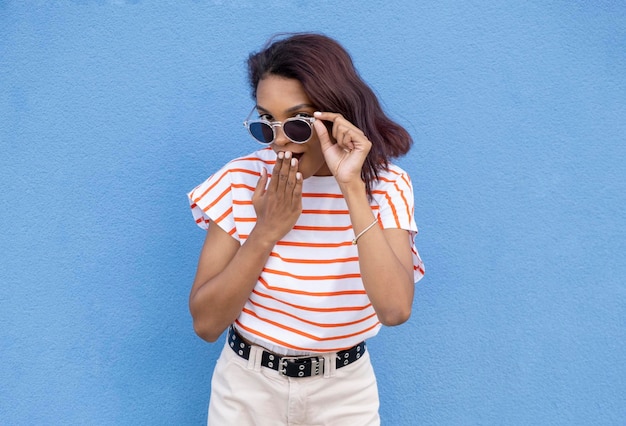 Image d'une femme afro-américaine confuse en lunettes de soleil regardant la caméra