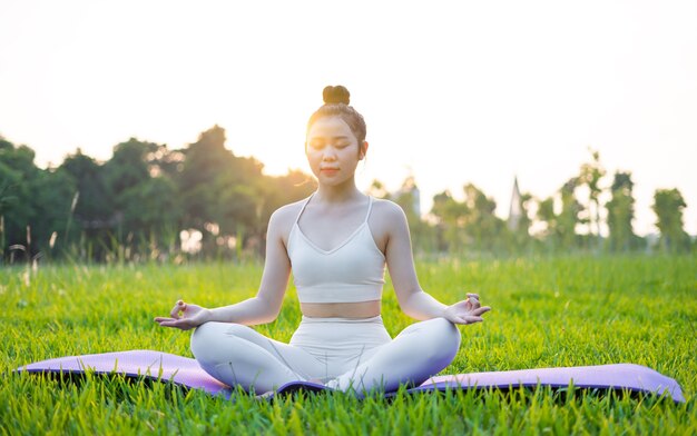 Image d'une femme asiatique faisant du yoga à l'extérieur