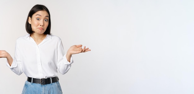 Image d'une femme de bureau de gestionnaire de bureau asiatique confuse haussant les épaules et regardant debout sans aucune idée