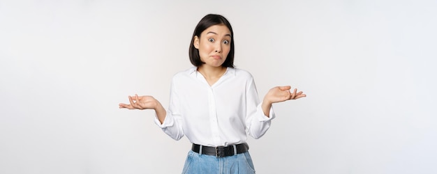 Image d'une femme de bureau de gestionnaire de bureau asiatique confuse haussant les épaules et regardant perplexe debout sur fond blanc