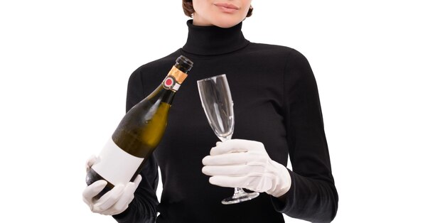 Image d'une femme avec une coupe de champagne et une bouteille dans les mains. Gants blancs. Fond de studio clair. Technique mixte