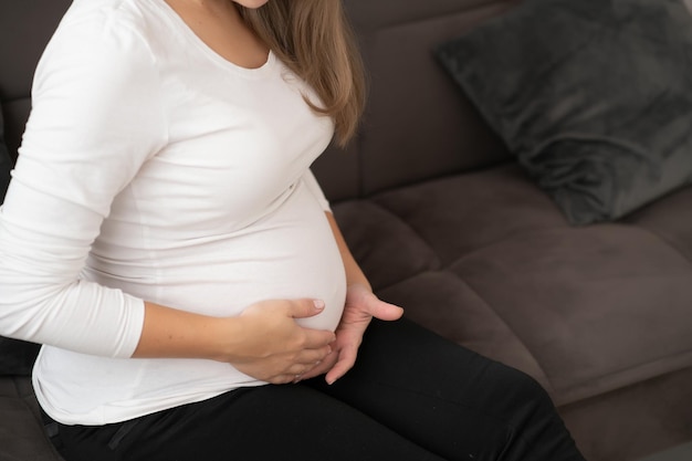 Image d'une femme enceinte touchant son ventre avec les mains