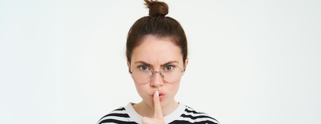Photo image d'une femme sérieuse dans des lunettes professeur taire fait taire taire geste appuyer le doigt sur les lèvres et