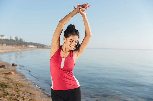 Image de femme sportive gaie l'échauffement et regardant vers le bas