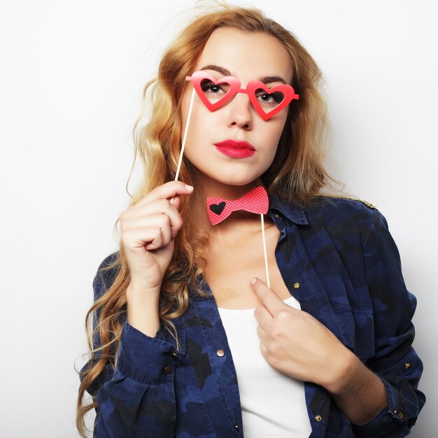 Image de fête Jeune femme espiègle tenant des lunettes de fête Prête pour du bon temps