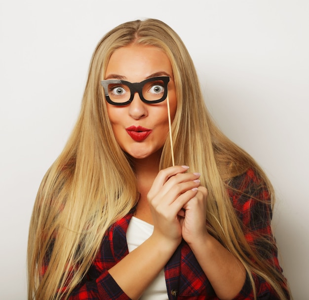 Image de fête Jeune femme tenant des lunettes de fête.