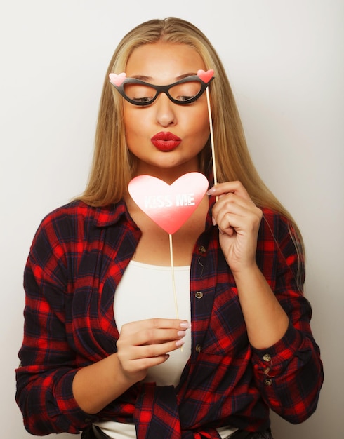 Image de fêteJeune femme tenant des lunettes de fête Sur fond blanc