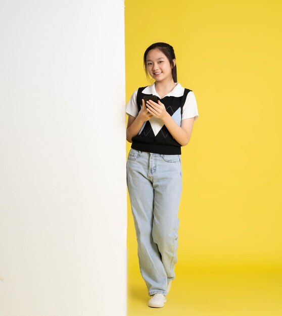 image d'une fille asiatique debout et utilisant un téléphone avec un panneau d'affichage