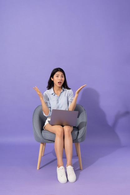 Image de fille assise sur un canapé isolé sur fond violet