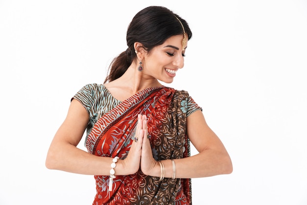 Image d'une fille hindoue heureuse portant un costume indien traditionnel ou une robe sari priant avec des palmiers ensemble isolés