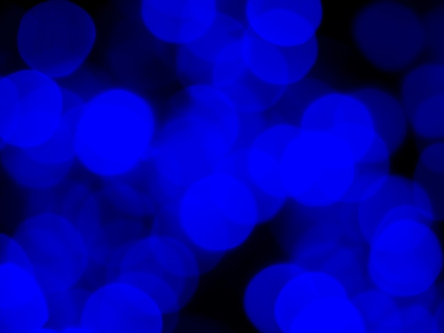 Image floue abstraite de la lumière bleue du beau bokeh sur fond noir Fête de nuit festive floue et arrière-plan bokeh de célébration