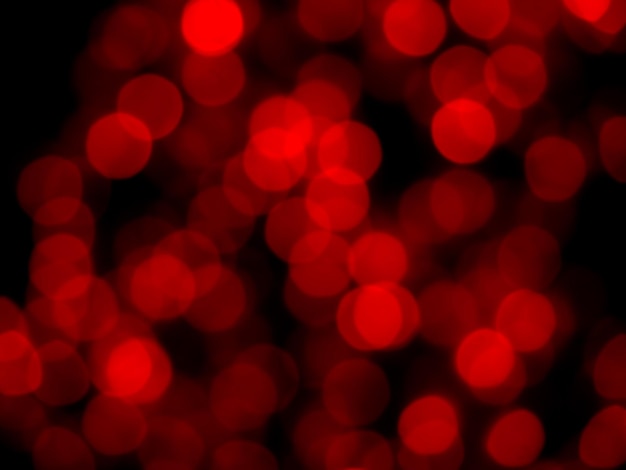 Image floue abstraite de la lumière rouge du bokeh de la fête de nuit sur fond sombre