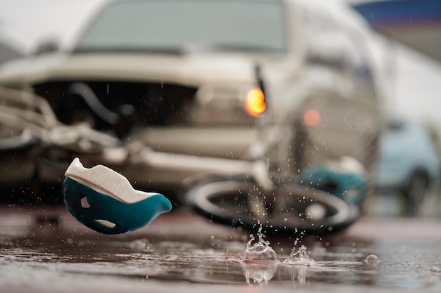 Image Floue D'un Casque D'accident De La Circulation Et D'un Vélo Après Qu'une Voiture S'écrase Sur Un Cycliste Sur La Route Lors D'une Forte Pluie