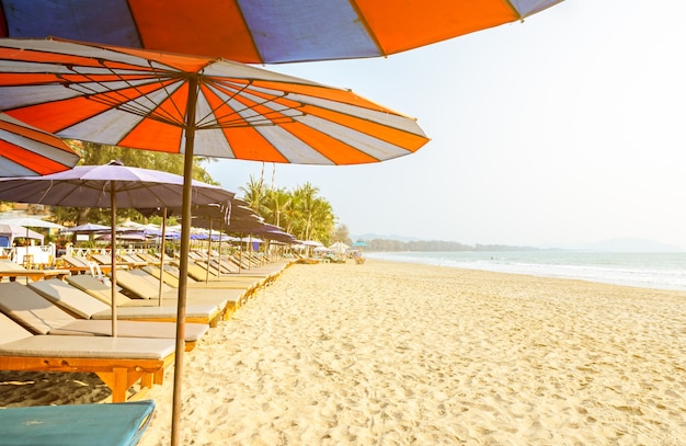 Image floue de chaises longues et parasol sur une plage tropicale