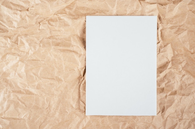 Image de fond de papier kraft texturé recyclé froissé rugueux avec une feuille de carton blanc sur le côté. Espace de copie