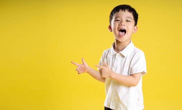 Image d'un garçon asiatique posant sur un fond jaune