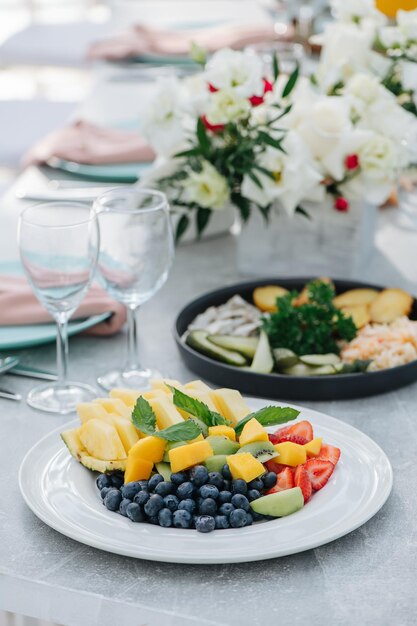 Image en gros plan d'une assiette avec des tranches de fruits et de baies sur une table de banquet