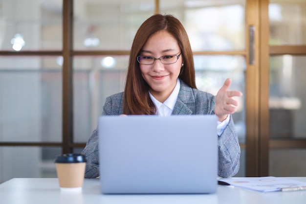 Image en gros plan d'une belle femme d'affaires utilisant un ordinateur portable pour travailler en ligne et en vidéoconférence