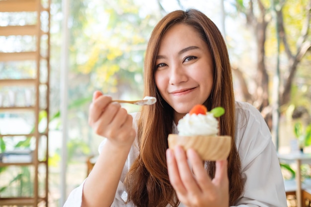 Image en gros plan d'une belle femme asiatique aime manger une glace au restaurant