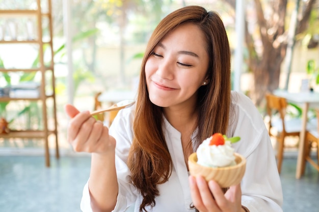 Image en gros plan d'une belle femme asiatique aime manger une glace au restaurant