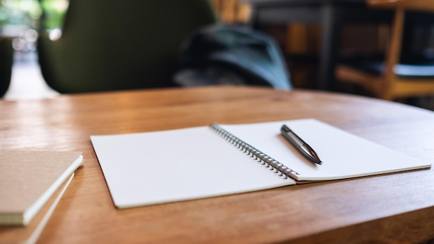 Image en gros plan d'un cahier et d'un stylo sur une table en bois