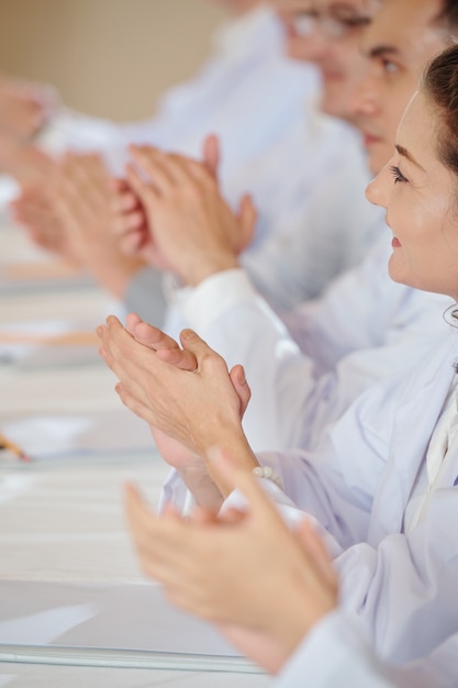 Image en gros plan de chercheurs applaudissant au conférencier lors d'une conférence médicale