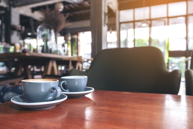 Image Gros plan de deux tasses bleues de café latte chaud sur une table en bois vintage au café