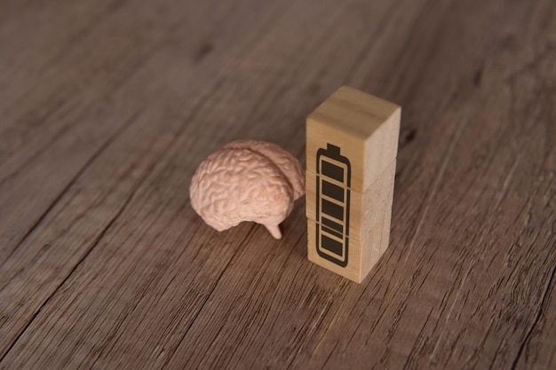 Photo image en gros plan du cerveau et des blocs de bois avec l'icône de la batterie à pleine énergie