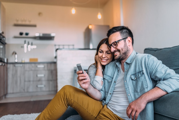 Image gros plan du couple en regardant à l&#39;écran du smartphone à l&#39;intérieur.