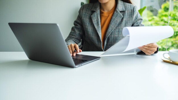 Image en gros plan d'une femme d'affaires utilisant un ordinateur portable tout en travaillant au bureau