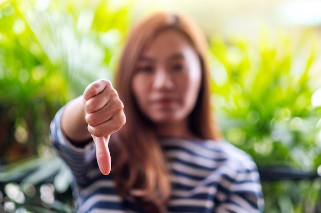 Image en gros plan d'une femme faisant et montrant le signe des mains vers le bas