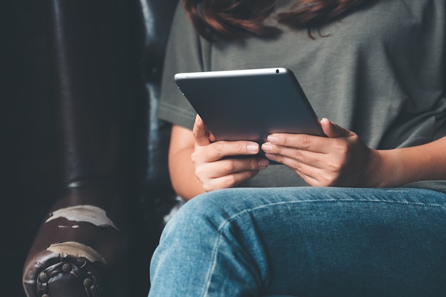 Image Gros plan d'une femme tenant et à l'aide de tablet pc dans un café moderne